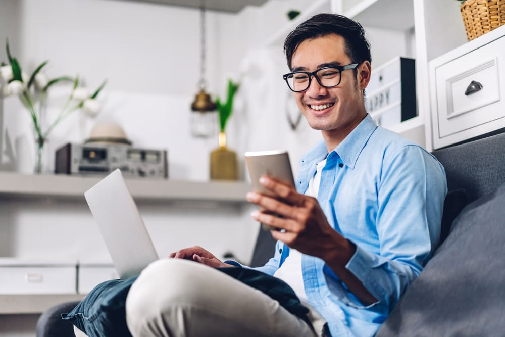 A man using his laptop and smartphone